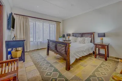 a bedroom with a bed and a large window at 42onKing in Centurion