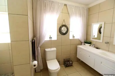 a bathroom with a toilet and a sink at Wilger Guesthouse in Centurion