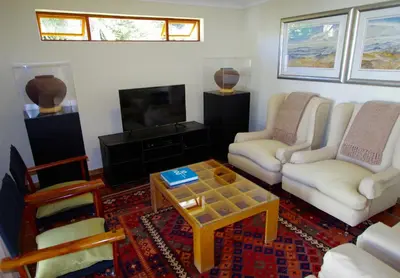 a living room with two chairs and a coffee table at Graskop Harrie's Cottage in Graskop