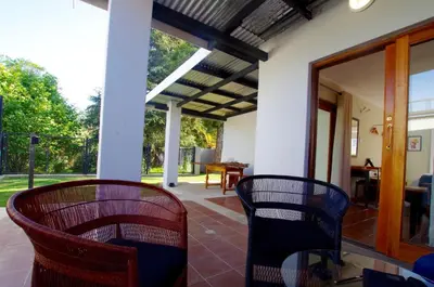 a porch with two chairs and a table at Graskop Harrie's Cottage in Graskop