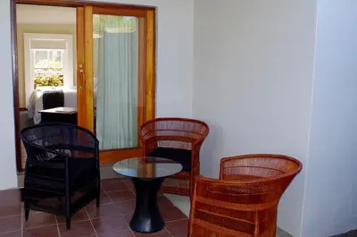a room with chairs and a table and a mirror at Graskop Harrie's Cottage in Graskop