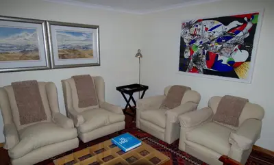 a living room with three chairs and a table at Graskop Harrie's Cottage in Graskop