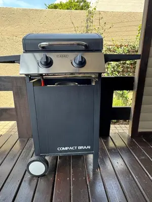 a barbecue grill sitting on a wooden deck at Timmerstuga in Malelane