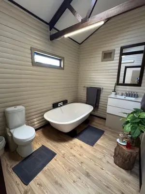 a bathroom with a tub and a toilet and a sink at Timmerstuga in Malelane