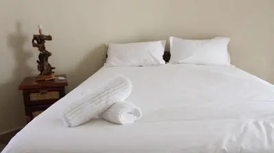 a white bed with a stuffed animal on it at Thabaledi Game Lodge in Brits