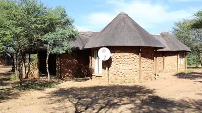 a small building with a thatched roof with a sign on it at Thabaledi Game Lodge in Brits