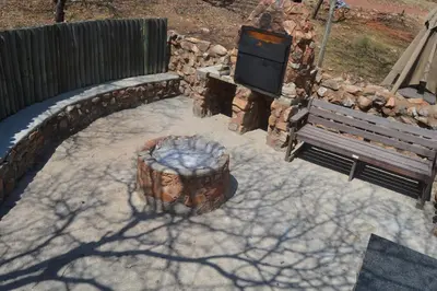 a patio with a fire pit and a bench at Thabaledi Game Lodge in Brits