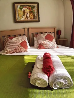 a bedroom with a bed with towels on it at Die Woestynroos Gastehuis in Isidule