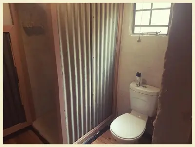 a bathroom with a toilet and a window at Die Woestynroos Gastehuis in Isidule