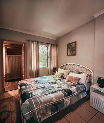 a bedroom with a bed and a window at Die Woestynroos Gastehuis in Isidule