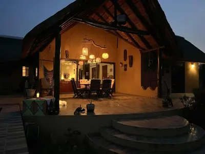 a house with a patio with a table and chairs at Bushvilla Umoja Kruger in Phalaborwa