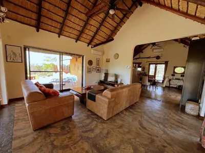 a living room with two couches and a table at Bushvilla Umoja Kruger in Phalaborwa