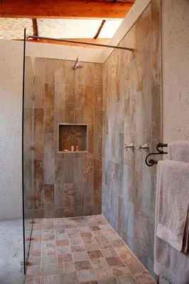 a bathroom with a shower with a fireplace at Kierieklapper in Hectorspruit