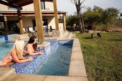 two women are sitting in a swimming pool at Kierieklapper in Hectorspruit