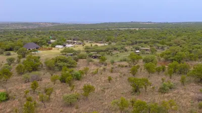 an aerial view of a forest with houses and trees at Thorn Tree Bush Camp in Klipdrift