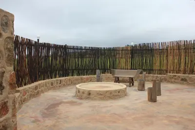 a stone patio with a bench and a fence at Riverman Cabin Country Lodge - Tonteldoos in Tonteldoos