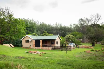 a small house in the middle of a field at Riverman Cabin Country Lodge - Tonteldoos in Tonteldoos
