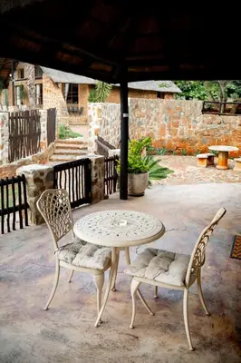 a table and two chairs sitting on a patio at Riverman Cabin Country Lodge - Tonteldoos in Tonteldoos