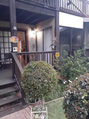 a porch of a house with two bushes at Kattekwaad Accommodation in Kaapsehoop