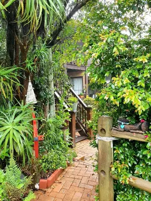 a garden with a wooden gate and a walkway at Kattekwaad Accommodation in Kaapsehoop