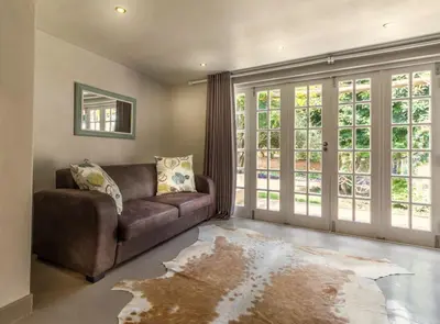 a living room with a couch and a large window at Pierneef's Kraal in Pretoria