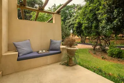 a blue couch sitting on a wall in a garden at Pierneef's Kraal in Pretoria