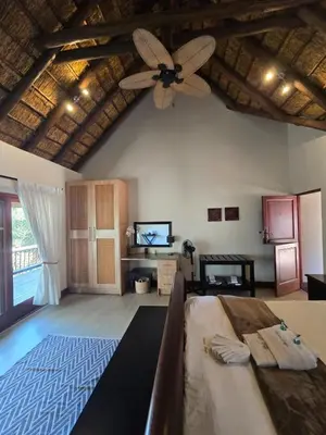 a large room with a ceiling fan and a bedroom at Mingwe Private Game Lodge in Mabula