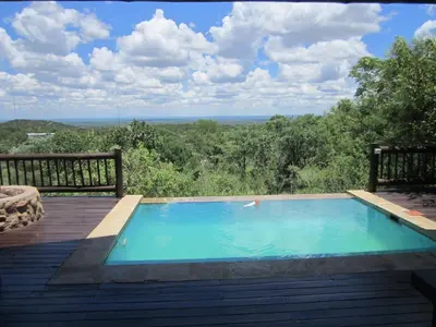 a swimming pool on a deck with a view at Mingwe Private Game Lodge in Mabula