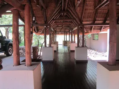a pavilion with white chairs and wooden beams at Mingwe Private Game Lodge in Mabula