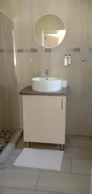 a bathroom with a white sink and a mirror at LightStone Guesthouse in Centurion