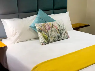 a bed with two pillows on top of it at Centurion Guest House and Lodge in Centurion