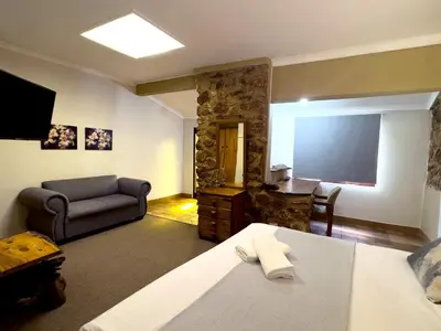 a room with a bed and a couch and a television at Centurion Guest House and Lodge in Centurion