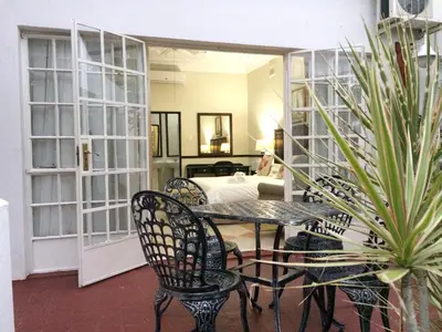 a room with a table and chairs and a bed at Polokwane Place in Polokwane