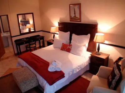 a bedroom with a bed with a teddy bear on it at Polokwane Place in Polokwane