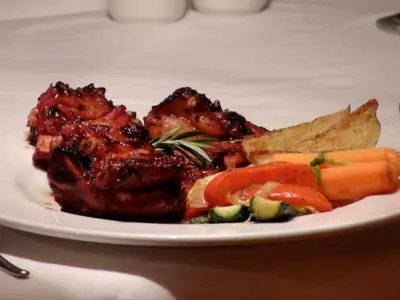 a plate of food with meat and vegetables on a table at Polokwane Place in Polokwane