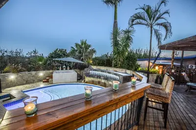 a deck with a plunge pool and a wooden table at The Rest Guest House in Nelspruit