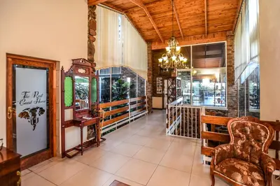 a lobby with a chair and a chandelier at The Rest Guest House in Nelspruit