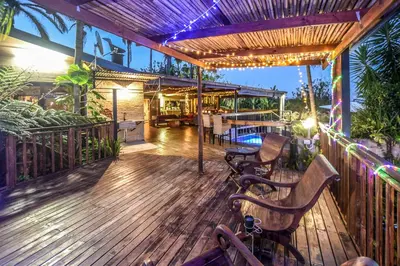 a wooden deck with a table and chairs on it at The Rest Guest House in Nelspruit