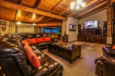 a living room with a leather couch and a coffee table at The Rest Guest House in Nelspruit