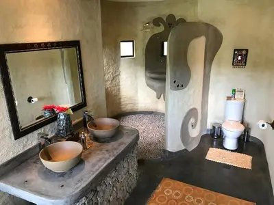 a bathroom with two sinks and a toilet and a mirror at Tinkers Lakeside Lodge - Kruger in White River
