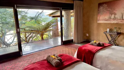 a hotel room with two beds and a large window at Tinkers Lakeside Lodge - Kruger in White River