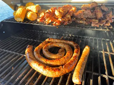 a bunch of sausages and other food on a grill at Tinkers Lakeside Lodge - Kruger in White River