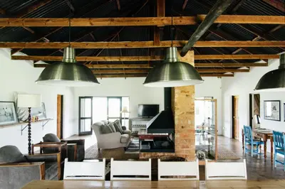 a living room with three large green pendant lights at The Cowshed in Lydenburg