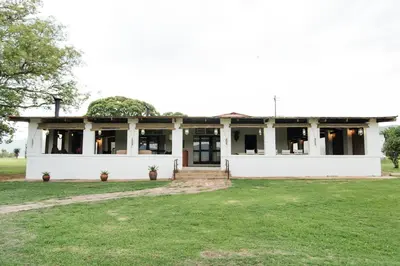 an old white house with windows and a yard at The Cowshed in Lydenburg