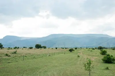 a field with mountains in the background at The Cowshed in Lydenburg