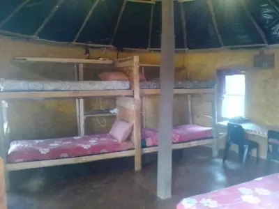 a room with two bunk beds in a hut at Joy River Backpackers in Moremela