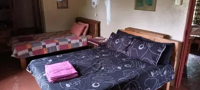 a bedroom with a bed and a couch at Joy River Backpackers in Moremela