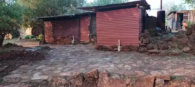 a small red building with a pile of rocks in front of it at Joy River Backpackers in Moremela