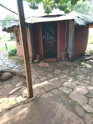 a small red building with a wooden door at Joy River Backpackers in Moremela