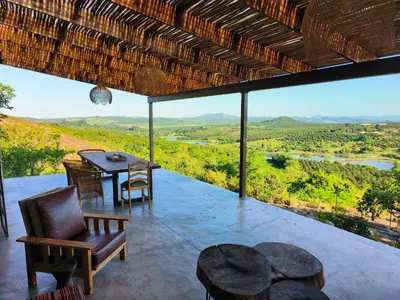a patio with a table and chairs and a view at Eloff Guest House and Gallery in White River